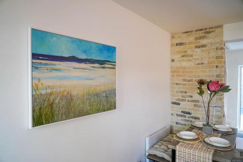 a painting hanging on a wall next to a table at Luxury holiday home in central Truro in Truro