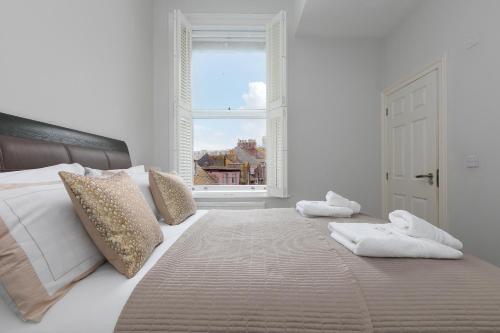 a bedroom with a large white bed with a window at Arghanti in St Ives
