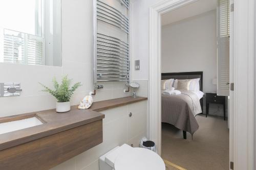 a bathroom with a sink and a bedroom with a bed at Arghanti in St Ives