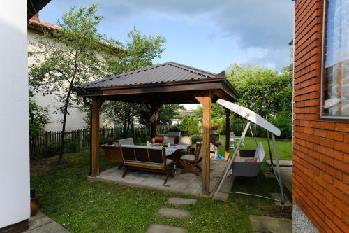 een tuinhuisje met een tafel en stoelen in de tuin bij The Cosmic Gate 3 in Biskupići
