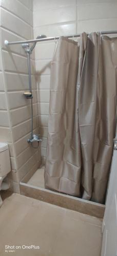 y baño con ducha y cortina de ducha. en Exquisite Villa Rentals at North Coast Marsiellia Beach 4 Families, en El Alamein