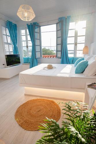 a large bedroom with a large bed with blue curtains at The White Rose Apartment in Poros