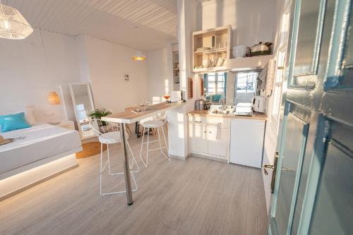 una pequeña cocina con mesa y sillas en una habitación en The White Rose Apartment, en Poros