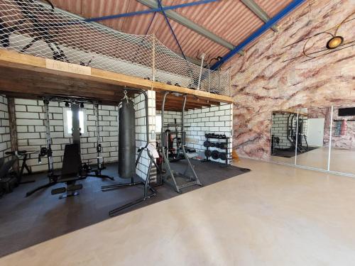 um ginásio com uma grande parede de pedra e equipamento de exercício em Chambre Merlot, piscine et spa, proche St Emilion em Lugon et l’Ile du Carney