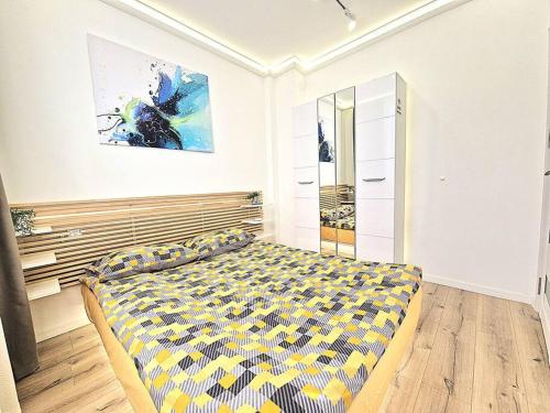 a bedroom with a bed and a painting on the wall at Art Apartment + 2BD parking space in Varna City