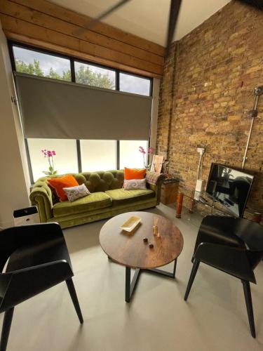 a living room with a couch and a table and chairs at Sleek & Central 1BD Flat - Battersea Park in London
