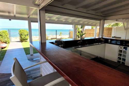 a kitchen with a counter with a view of the ocean at Maison bord de mer in Le Gosier