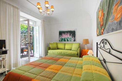 a bedroom with a bed and a green couch at Casa Augusto B&B in Capri