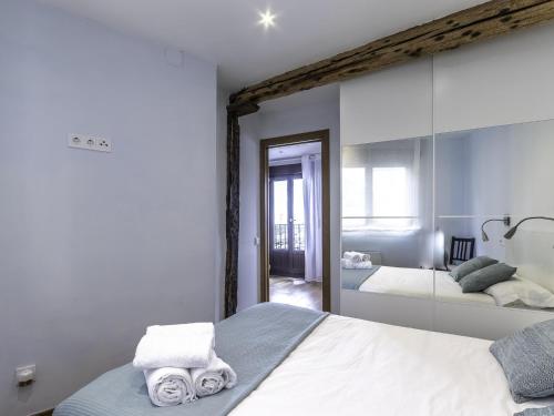 um quarto branco com uma cama e um espelho em Politxe By Kabia Gestión em Bermeo