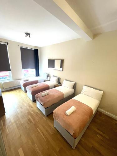 Habitación de hotel con 3 camas y sofá en Camden Budget Suites - Next to Station and Camden Market, en Londres