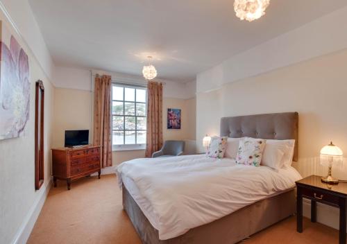 a bedroom with a large bed and a television at Bayards Cottage in Dartmouth