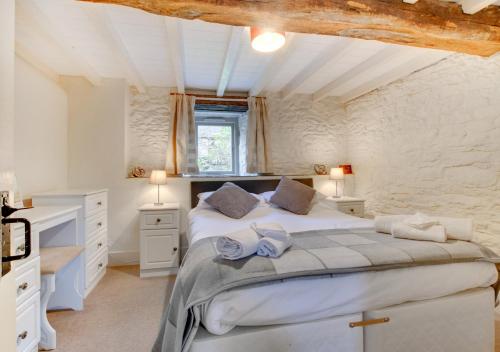 a bedroom with a large white bed in a room at Bovey Cottage in Broadhempston