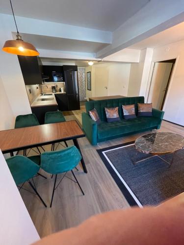 uma sala de estar com um sofá verde e uma mesa em The Park House Suite, Jakobstad em Pietarsaari