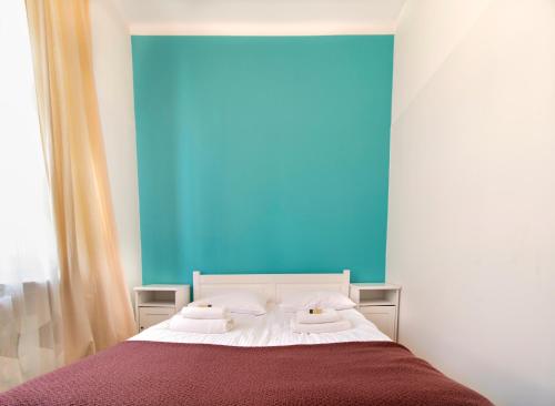 um quarto com uma cama com uma parede azul em Spacious Apartments Zyblikiewicza Street na Cracóvia