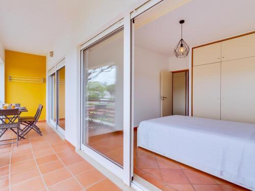 ヴィラモウラにあるAL - Apartamento Village Atlânticoのベッドルーム1室(ベッド1台、ダイニングテーブル付)