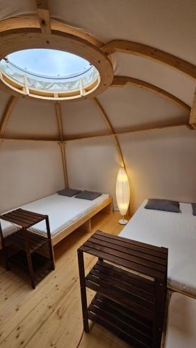 een kamer met 2 bedden en een raam bij fitneXX Zelt-Dorf in Balsthal