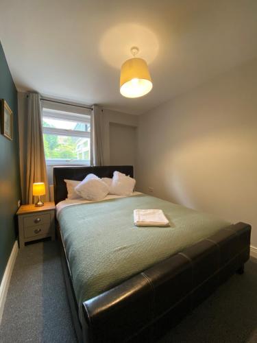 a bedroom with a bed with a lamp and a window at Spacious 4 Bedroom House in Northampton by HP Accommodation - Free Private Parking in Northampton