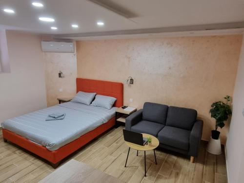 a bedroom with a bed and a couch at Apartman DoDoLuLu in Belgrade