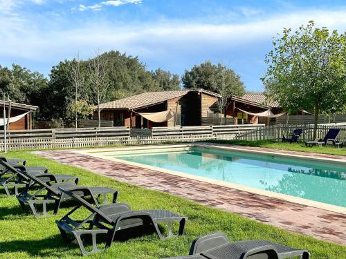 a swimming pool with lounge chairs in the grass at Càmping Rural Montori in Ultramort