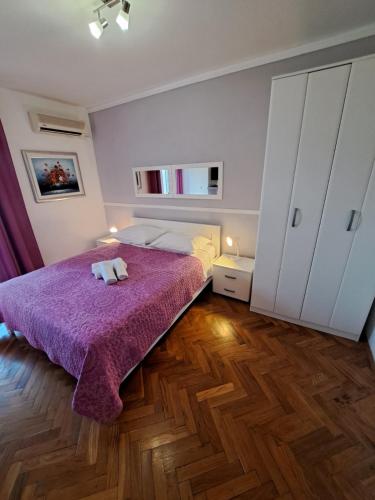 a bedroom with a bed with a purple blanket at Guesthouse Villa Stanovic Vlaho in Cavtat