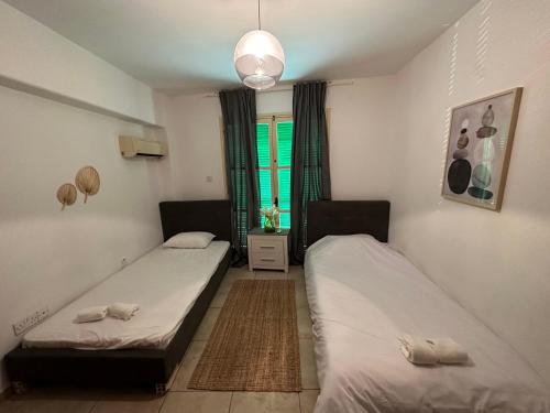 a room with two beds and a window at Private room in shared flat in Nicosia