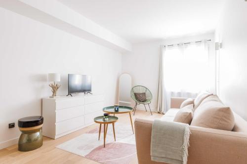 a white living room with a couch and a tv at Amazing Appartement - 6P2BDR - La DéfensePuteaux in Puteaux
