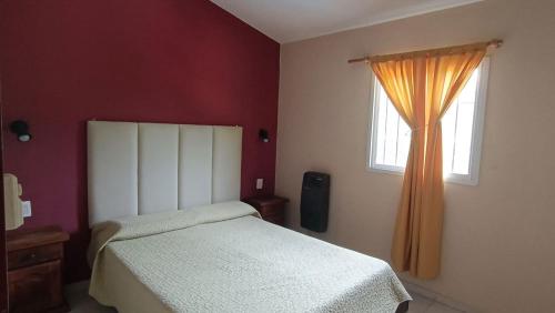 a bedroom with a bed and a window at Cabañas Los Pinos in Potrero de los Funes