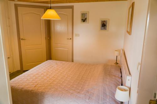 um quarto com uma cama e uma luz amarela em Pothuus 2 persoons vrijstaand huis met vrij uitzicht in de Achterhoek em Ruurlo
