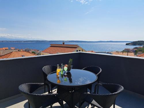a table on a balcony with a view of the water at Penthouse Petra with hot tub in Kali