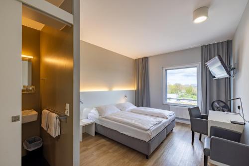 um quarto de hotel com uma cama e uma janela em mk hotel stuttgart em Stuttgart