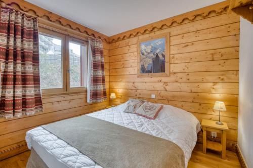 um quarto com uma cama num quarto com paredes de madeira em Appartments in Tignes Ecrin des Neiges em Tignes