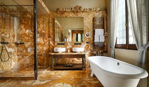 a bathroom with a tub and two sinks and a mirror at Palazzo Venart Luxury Hotel in Venice