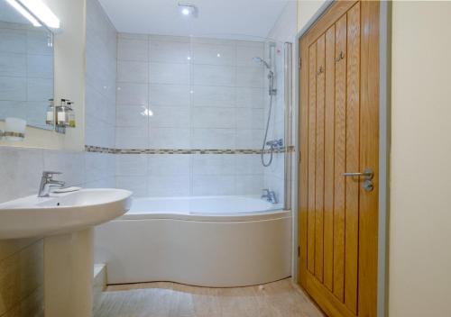 a bathroom with a tub and a sink and a shower at Teign Cottage in Broadhempston