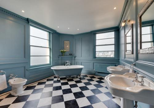 a bathroom with two sinks and a tub and two toilets at Vane Hill Crest in Torquay