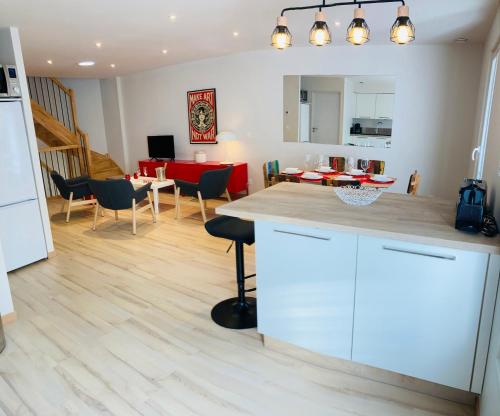 une cuisine et un salon avec une table et des chaises dans l'établissement Appartement neuf, centre ville d'Agde, à Agde