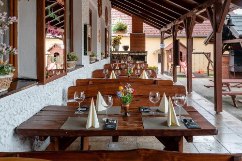a restaurant with a wooden table with wine glasses at Penzion U Kapličky in Malá Hraštice