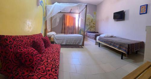 a living room with a red couch and a bed at Africa 6 Plage in Somone