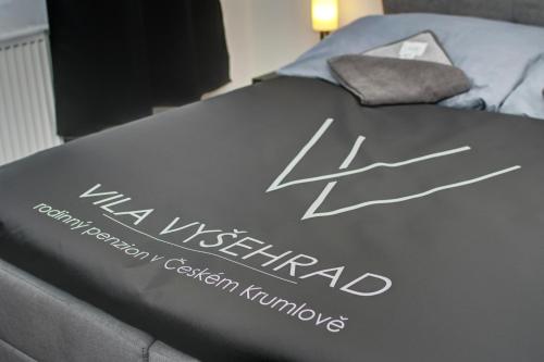 a bed with a sign on top of it at Vila Vyšehrad in Český Krumlov