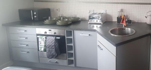 a kitchen with a counter with a sink and a stove at Easy Stay London - Bright and airy 2Bed Apart in London