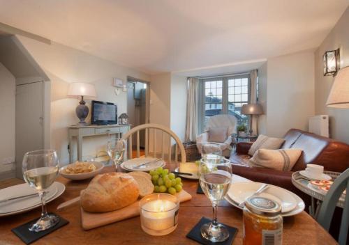 a table with bread and wine glasses on top of it at Compass Cottage Shaldon in Shaldon