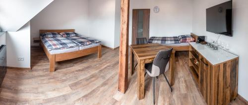 a bedroom with a bed and a desk and a desk at Penzion U Kapličky in Malá Hraštice