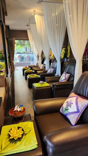 a row of leather couches in a room with curtains at Alaita Boutique Phuket in Ban Bo Rae