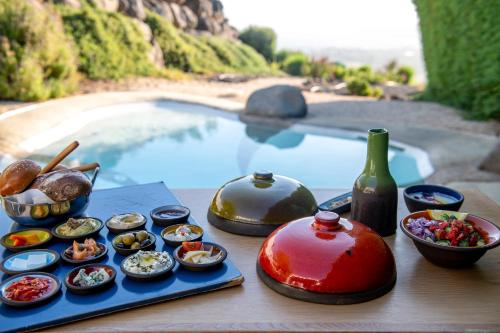 una mesa con tazones de comida junto a una piscina en Adika, en Ma'ale Gamla