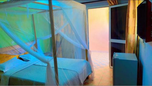 a bedroom with a bed with a blue curtain at Africa 6 Plage in Somone