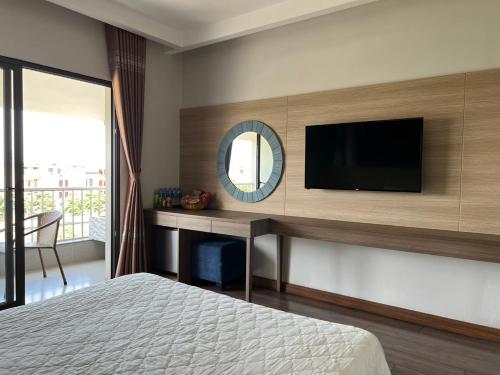 a bedroom with a tv and a desk with a bed at Khách Sạn Sông Lô in Hải Dương