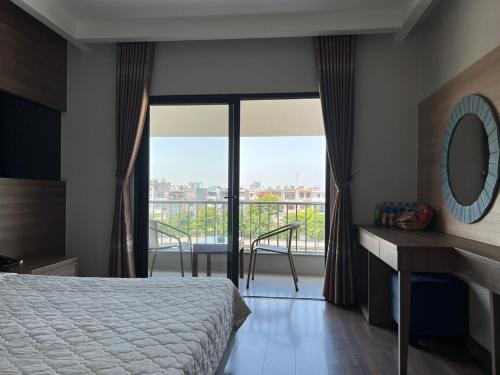 1 dormitorio con 1 cama y balcón con vistas. en Khách Sạn Sông Lô en Hải Dương