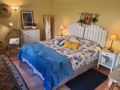 a bedroom with a bed with a blue and white comforter at TY La Source in Plestin-les-Grèves