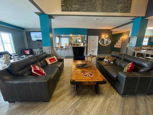 una sala de estar con 2 sofás de cuero y una mesa. en River Hills Hotel- Mankato, en Mankato