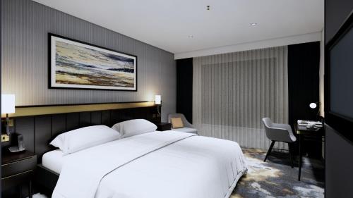 a bedroom with a large white bed and a desk at Mercure Paignton Hotel in Paignton
