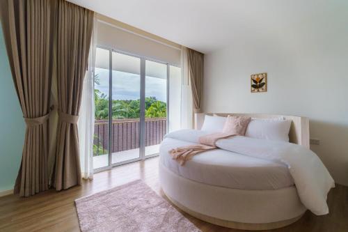 a bedroom with a large bed with a large window at The Pin Boutique Pool Villa Krabi in Ao Nang Beach